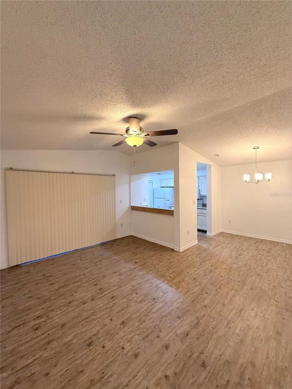 202 Riverbend Drive, Unit 201 Altamonte Springs, FL 32714 - Photo 2 of 13 a view of an empty room with a chandelier fan and wooden floor