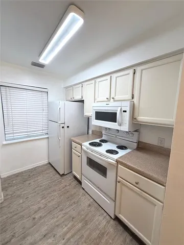 a kitchen with a stove top oven and refrigerator