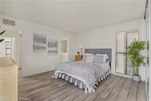 a bedroom with a large bed and a potted plant