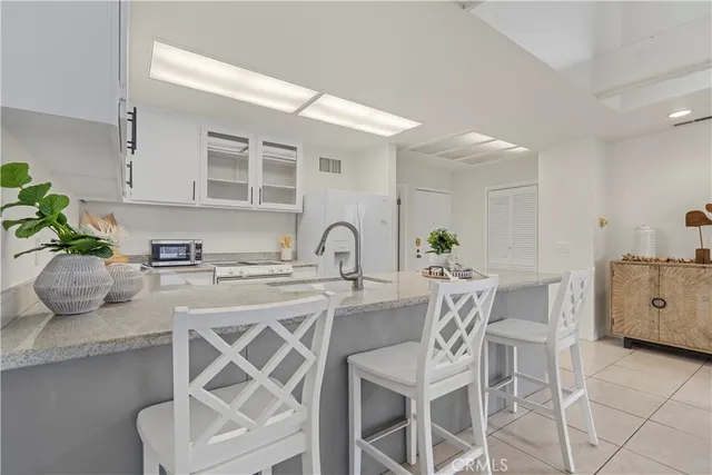 a white kitchen with a table and chairs