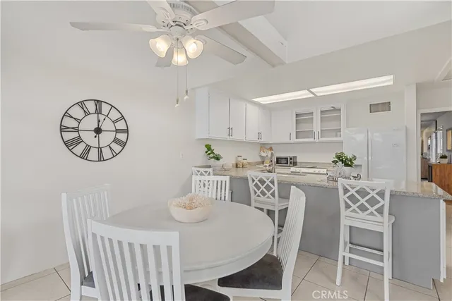 a view of a dining room with furniture a kitchen and chandelier