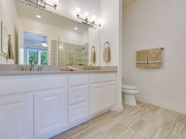 a bathroom with a granite countertop sink a toilet and shower