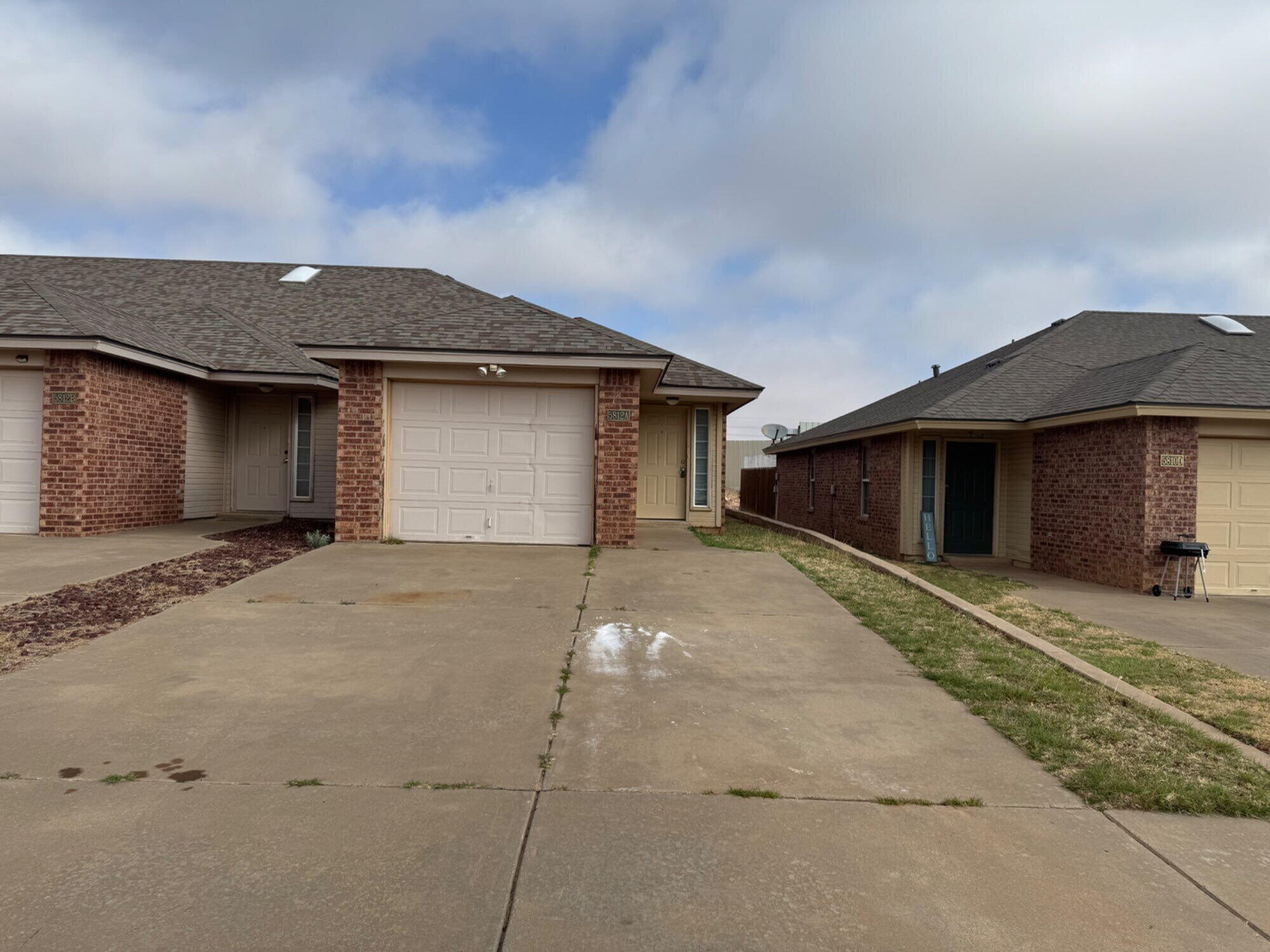 5812 6th Street, Unit A Lubbock, TX 79416 - Photo 1 of 7 a front view of a house with a yard and garage