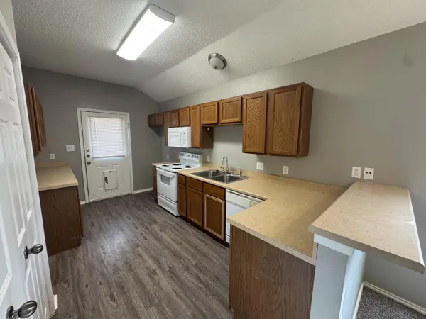 a kitchen with a sink a stove refrigerator and cabinets