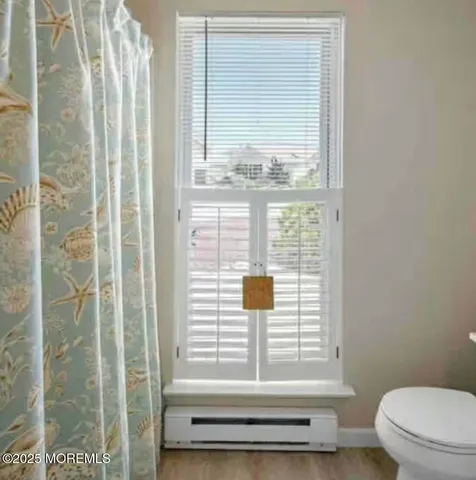 a bathroom with a window and a toilet