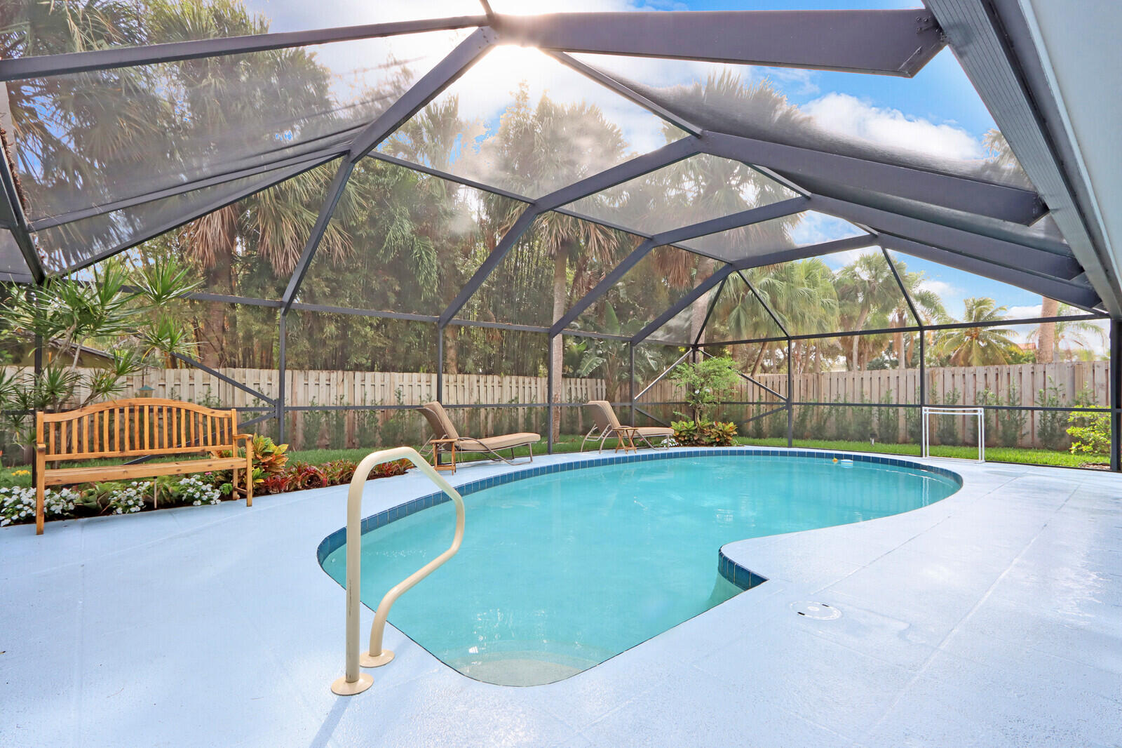 905 Sandy Oaks Drive Jupiter, FL 33477 - Photo 28 of 51 a view of a swimming pool with a patio and wooden fence