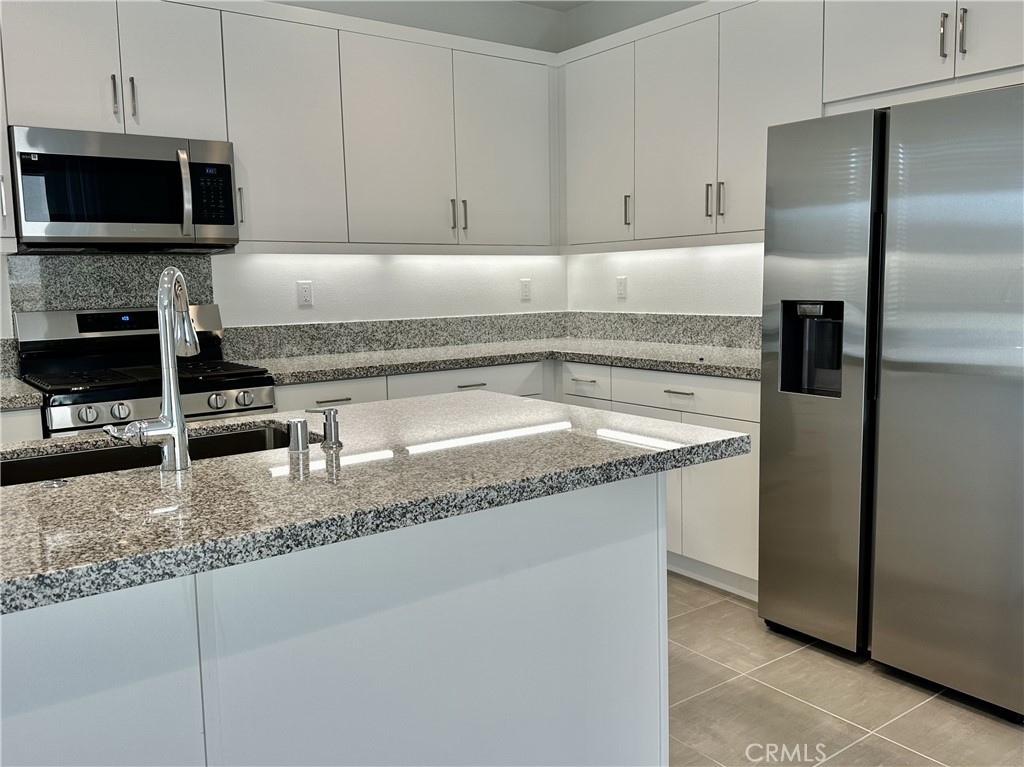 35878 McCarthy Street Palm Desert, CA 92211 - Photo 4 of 26 a kitchen with granite countertop a sink and a microwave