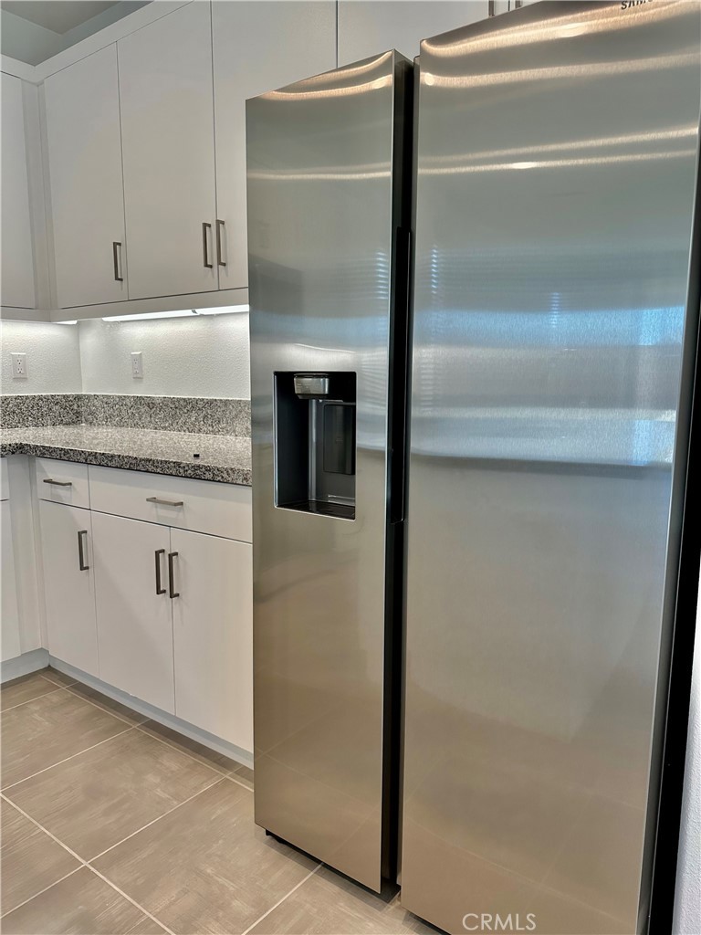 35878 McCarthy Street Palm Desert, CA 92211 - Photo 5 of 26 a kitchen with white cabinets and a refrigerator