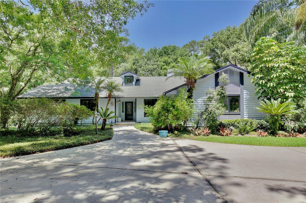 a front view of a house with a yard and potted plants