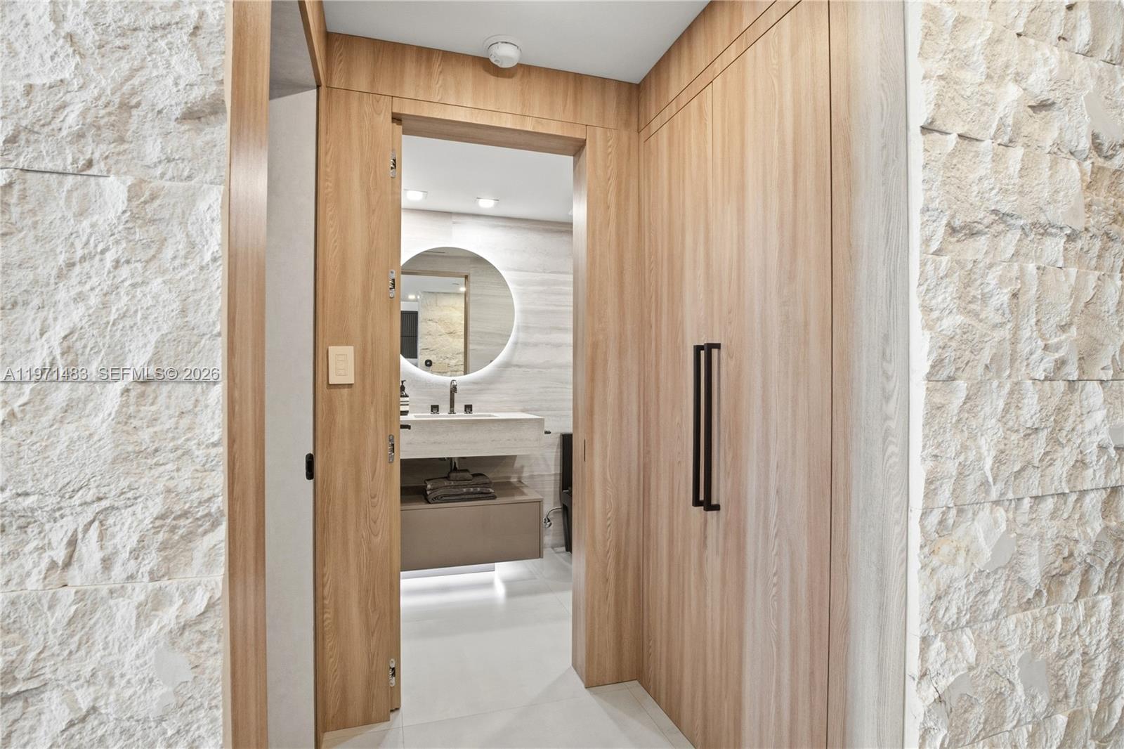 2127 Brickell Avenue, Unit 904 Miami, FL 33129 - Photo 30 of 38 a bathroom with a granite countertop sink a mirror and shower