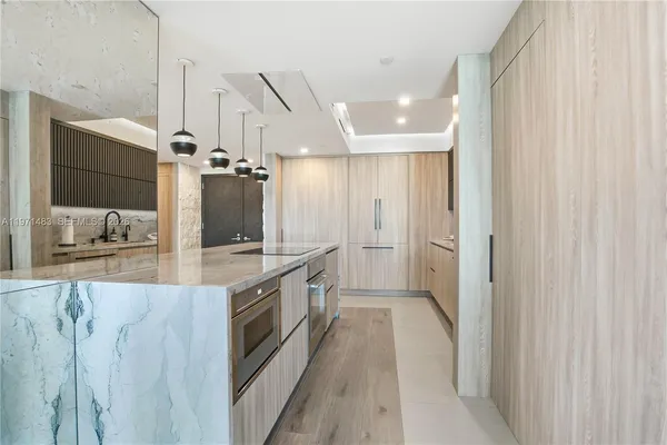 a large kitchen with a large counter top sink and stainless steel appliances