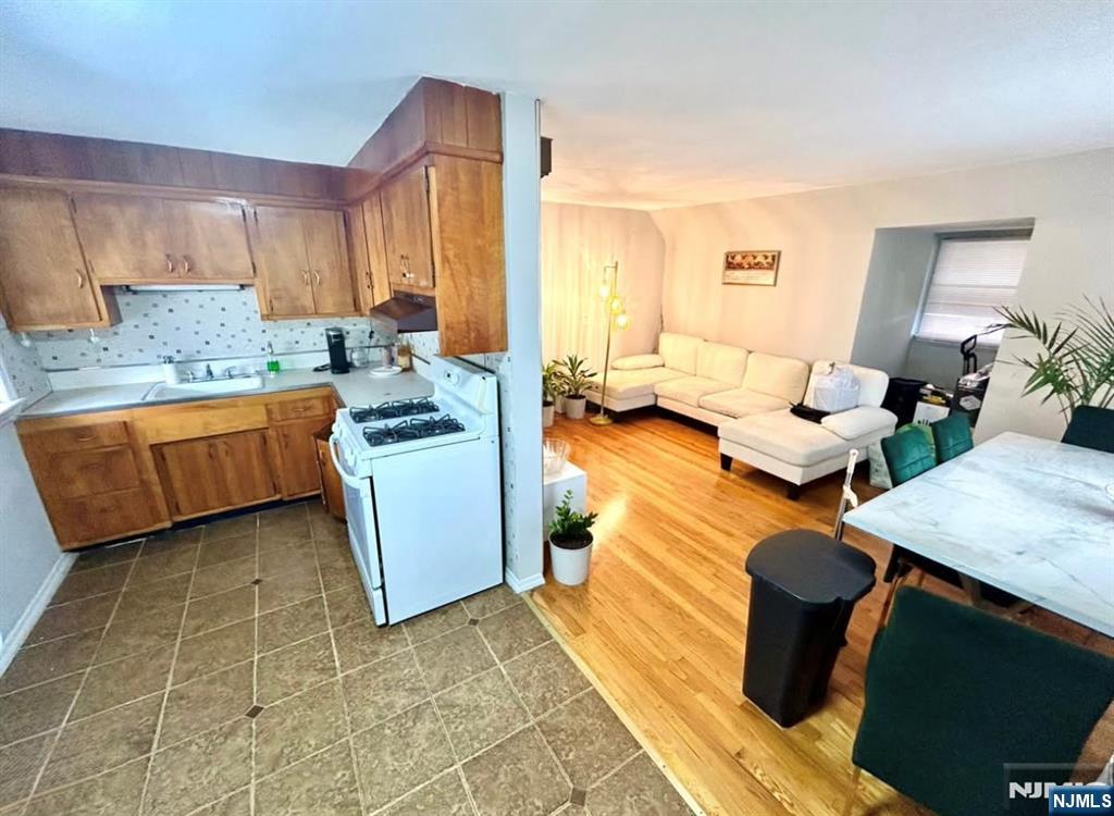 134-136 Canterbury Avenue, Unit 2 North Arlington, NJ 07031 - Photo 3 of 8 a kitchen with stainless steel appliances kitchen island granite countertop a sink and white cabinets