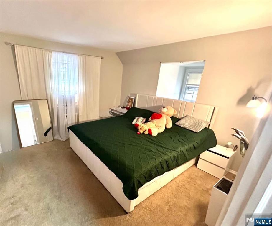 134-136 Canterbury Avenue, Unit 2 North Arlington, NJ 07031 - Photo 6 of 8 a bed sitting in a bedroom next to a window with pc on the table