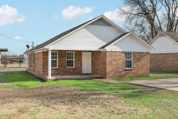 a view of a house with a yard and pathway