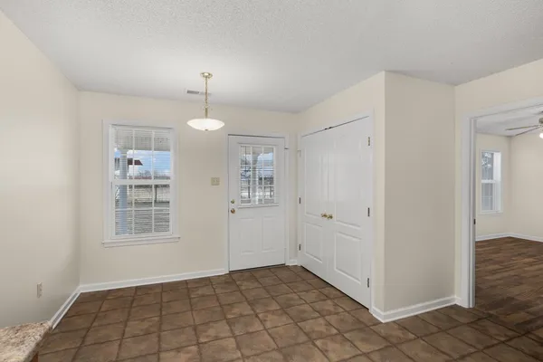 a view of an empty room with window and cabinet