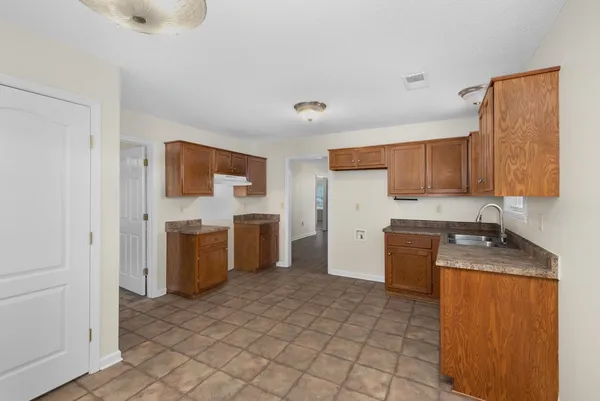 a kitchen with a refrigerator sink and wooden cabinets