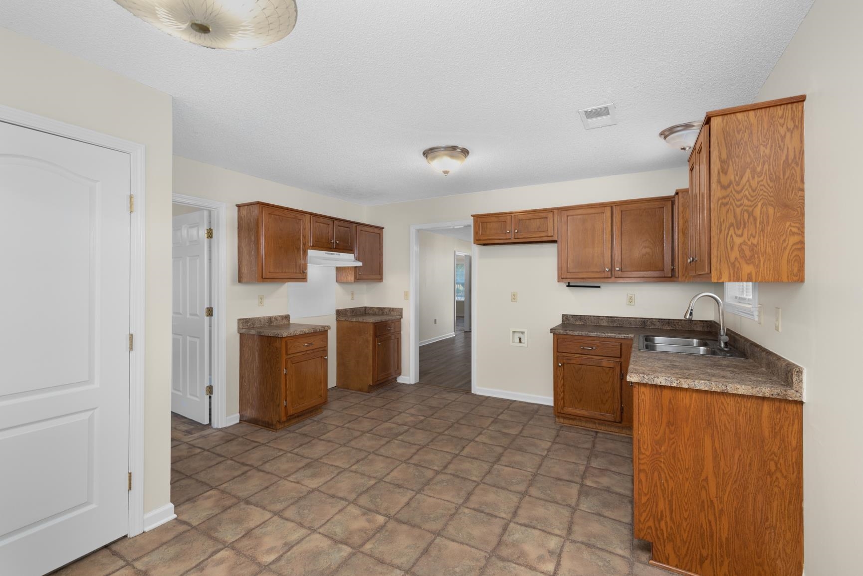 212 Feezor Street Covington, TN 38019 - Photo 16 of 31 a kitchen with a refrigerator sink and wooden cabinets