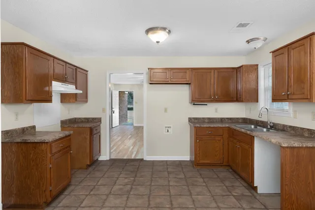 a kitchen with stainless steel appliances granite countertop a stove top oven a sink dishwasher and a refrigerator
