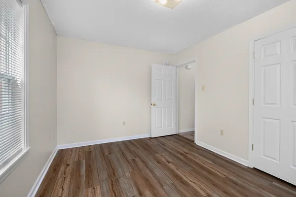 a view of an empty room with wooden floor