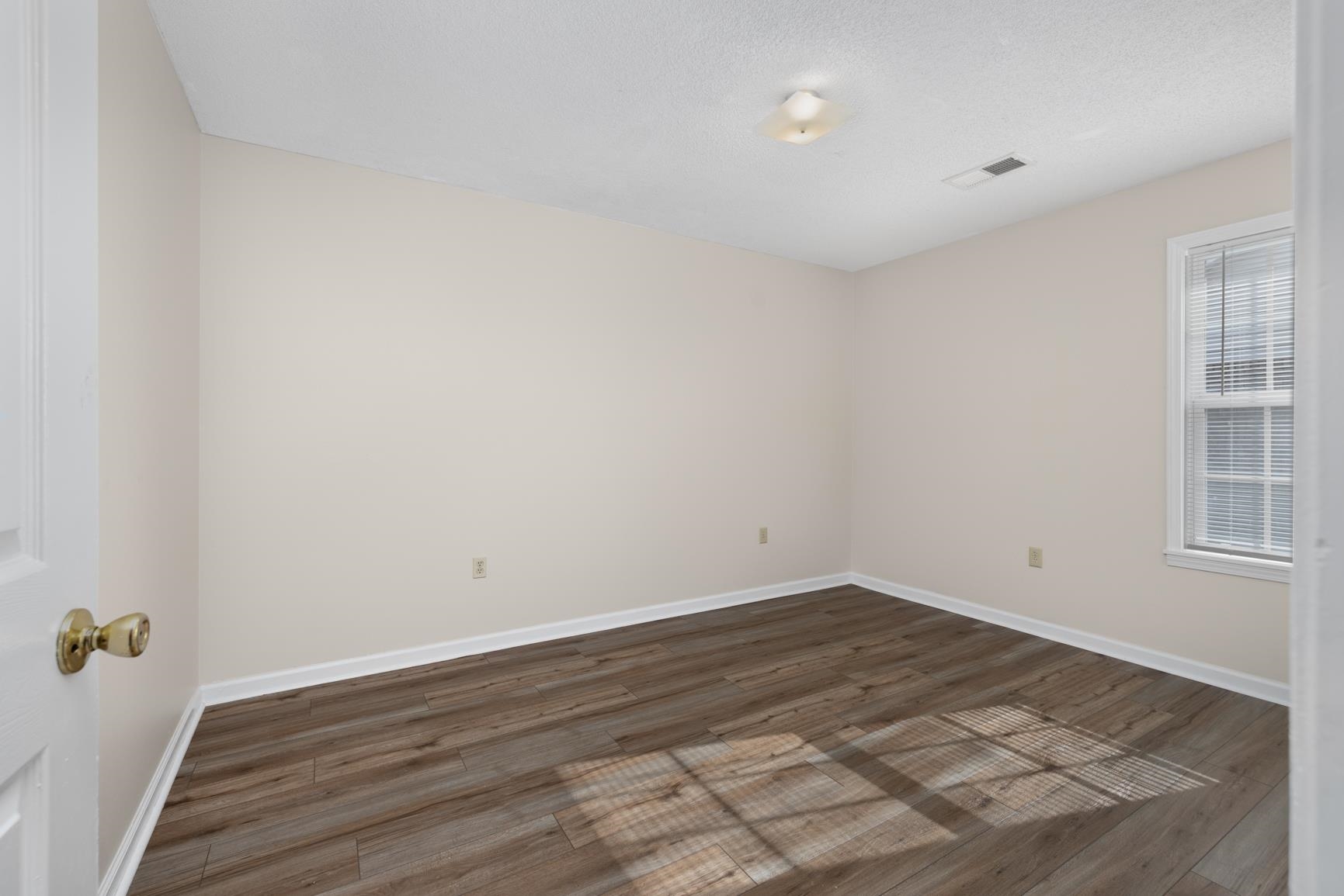 212 Feezor Street Covington, TN 38019 - Photo 25 of 31 a view of an empty room with wooden floor and a window
