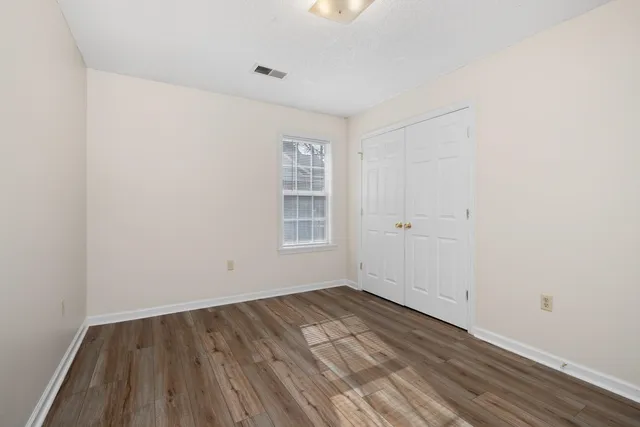 a view of a room with wooden floor and window