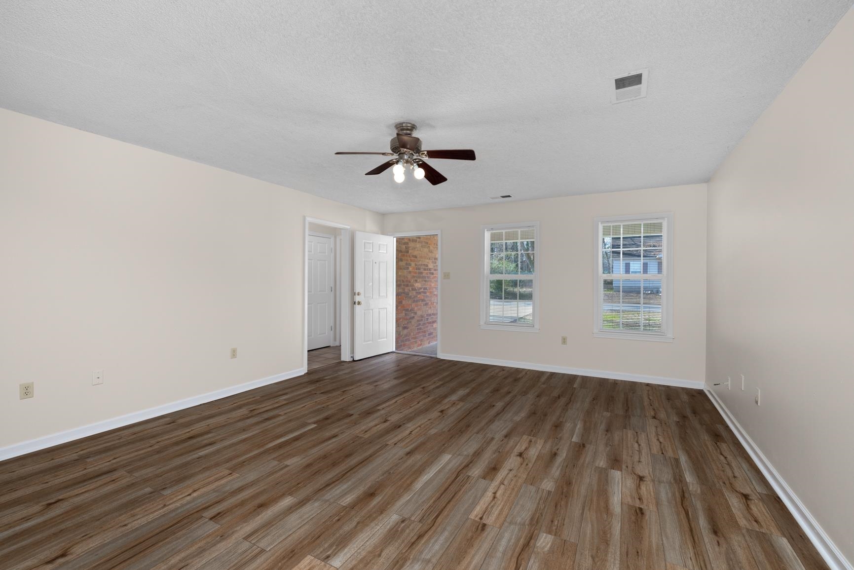 212 Feezor Street Covington, TN 38019 - Photo 6 of 31 wooden floor in an empty room with a window