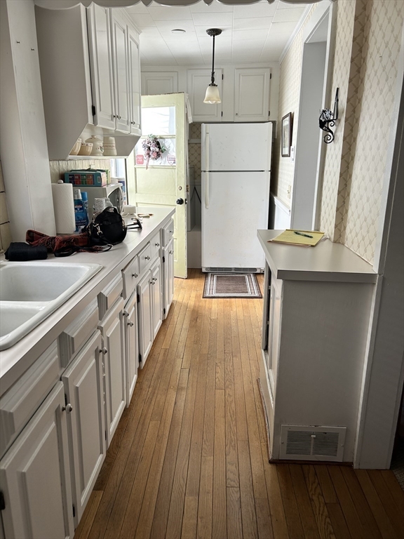 20 Shawmut Avenue New Bedford, MA 02740 - Photo 12 of 29 a kitchen with kitchen island wooden floors stainless steel appliances a sink and a refrigerator