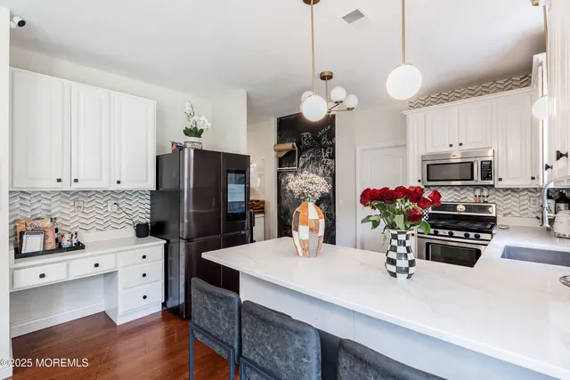 a kitchen with stainless steel appliances a sink refrigerator stove and microwave