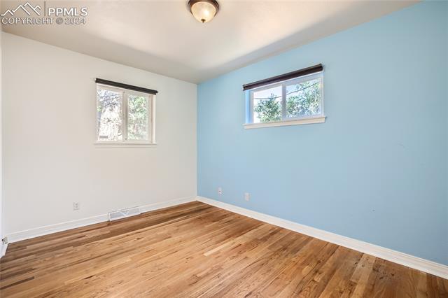 423 Yellowstone Road Colorado Springs, CO 80910 - Photo 9 of 13 Bedroom featuring a wealth of natural light and hardwood style floors