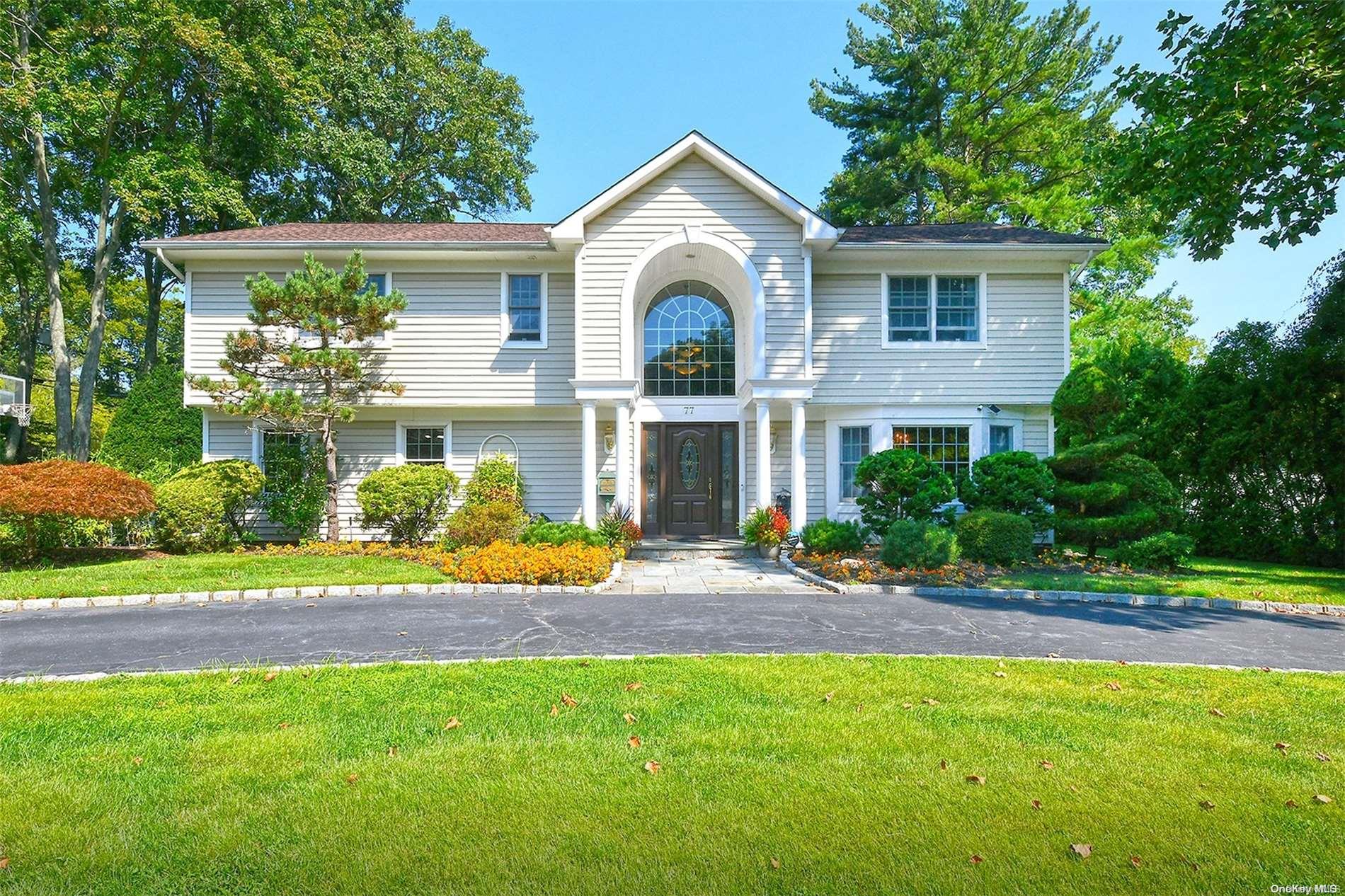 a front view of a house with a yard and potted plants
