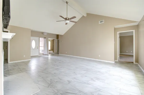 an empty room with fan and windows