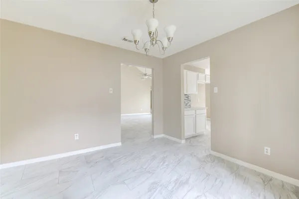 wooden floor in an empty room with a chandelier