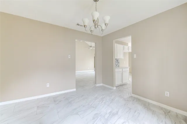 wooden floor in an empty room with a chandelier