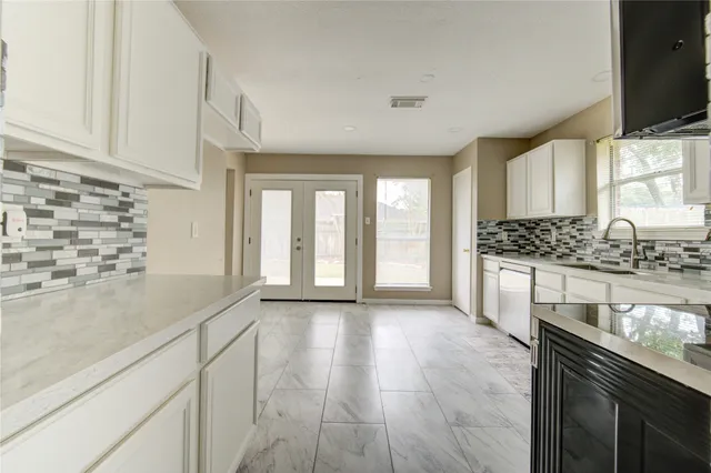 a kitchen with granite countertop a sink and a stove top oven