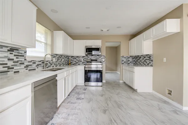 a kitchen with a stove top oven and cabinets