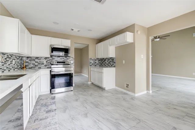 a kitchen with stainless steel appliances a stove sink and cabinets