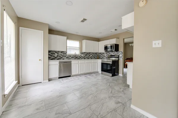 a kitchen with stainless steel appliances granite countertop a stove and a refrigerator