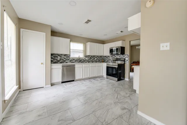a kitchen with stainless steel appliances granite countertop a stove and a refrigerator