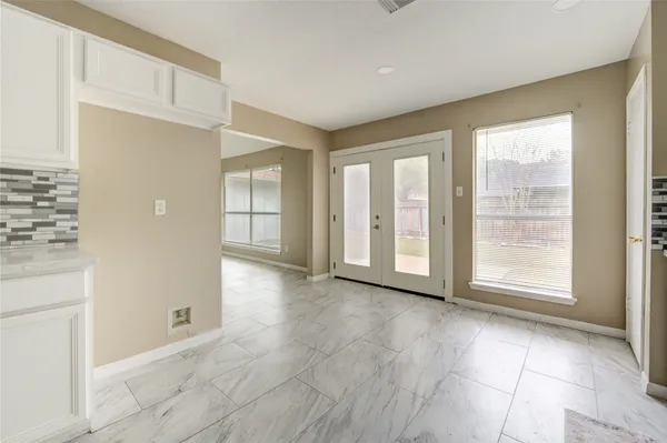 an empty room with windows and ceiling fan