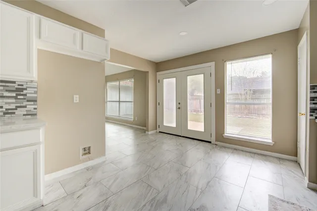 an empty room with windows and ceiling fan