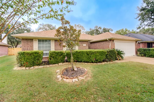a view of a white house with a yard and potted plants