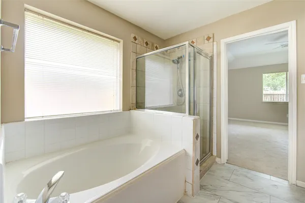a bathroom with a tub sink and mirror