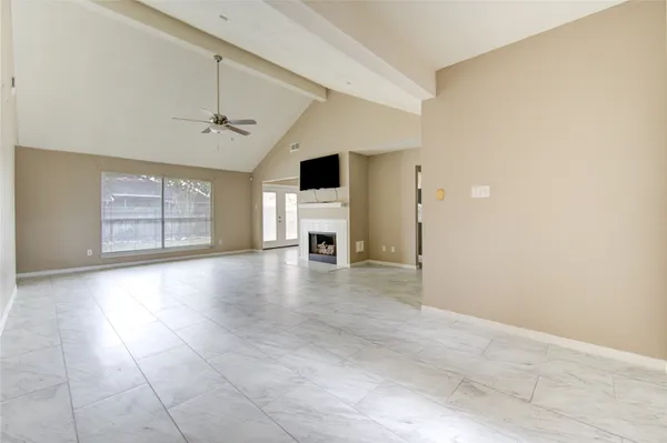 an empty room with windows and fireplace