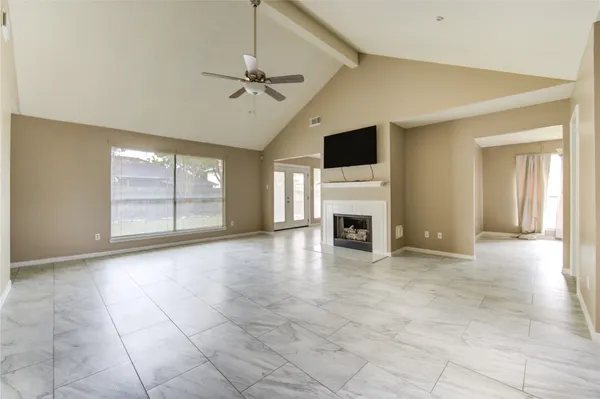 a view of an empty room with a fireplace and a window