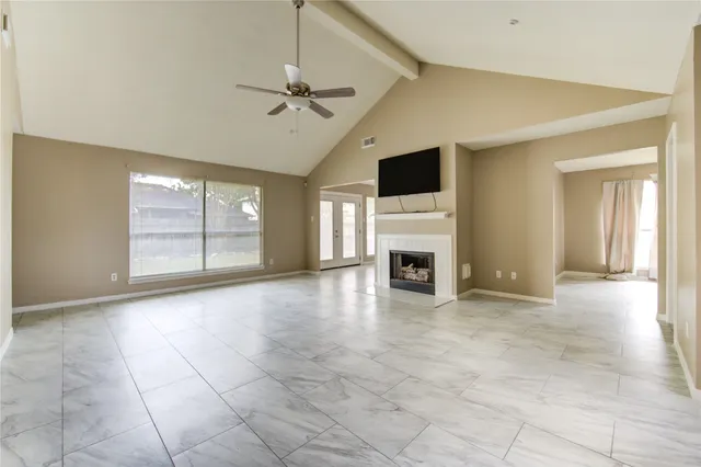 a view of an empty room with a fireplace and a window