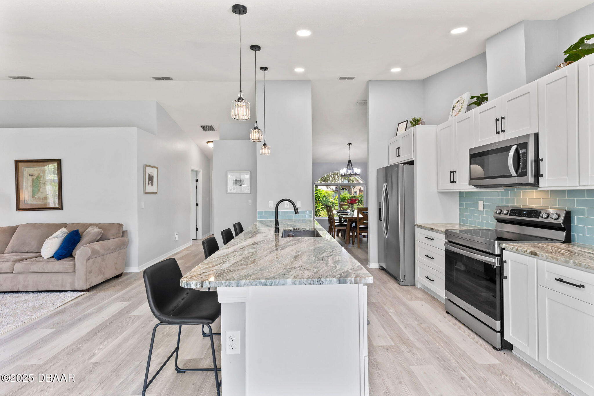 35 China Moon Drive Ormond Beach, FL 32174 - Photo 10 of 40 a kitchen with stainless steel appliances granite countertop a stove a sink a refrigerator and a dining table with wooden floor