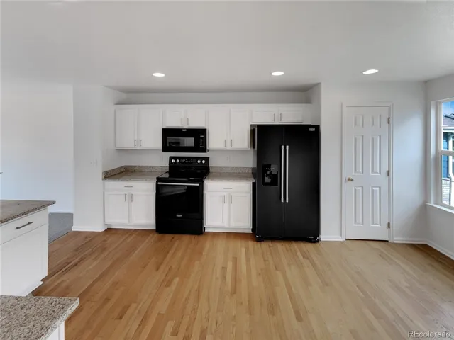 a kitchen with stainless steel appliances granite countertop a refrigerator and a stove top oven