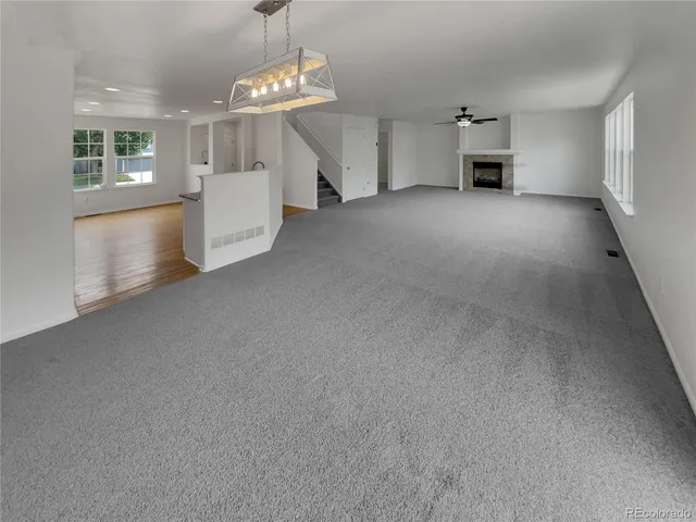 an empty room with chandelier and windows