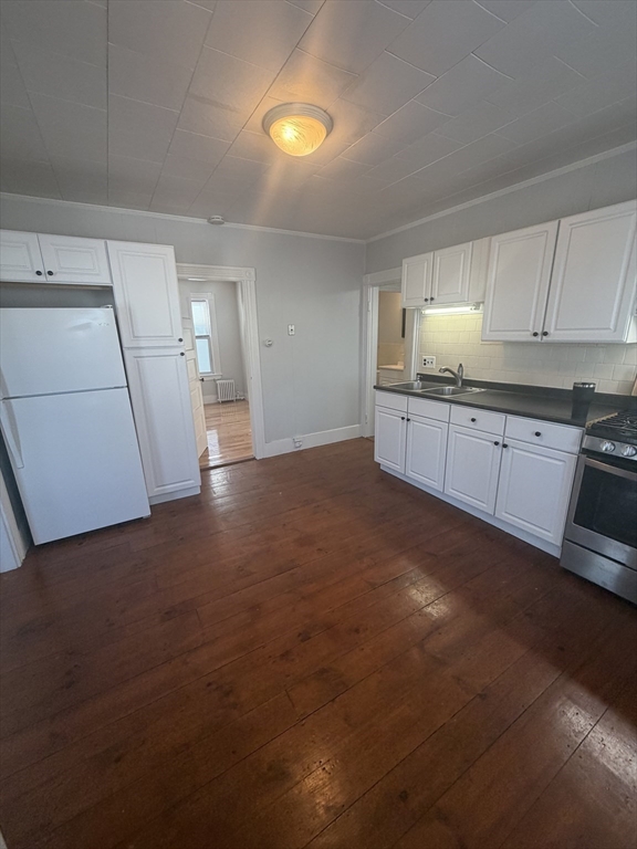 a kitchen with granite countertop a sink stove and cabinets