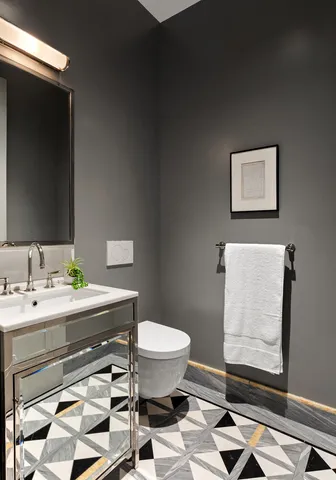 a bathroom with a toilet sink and mirror